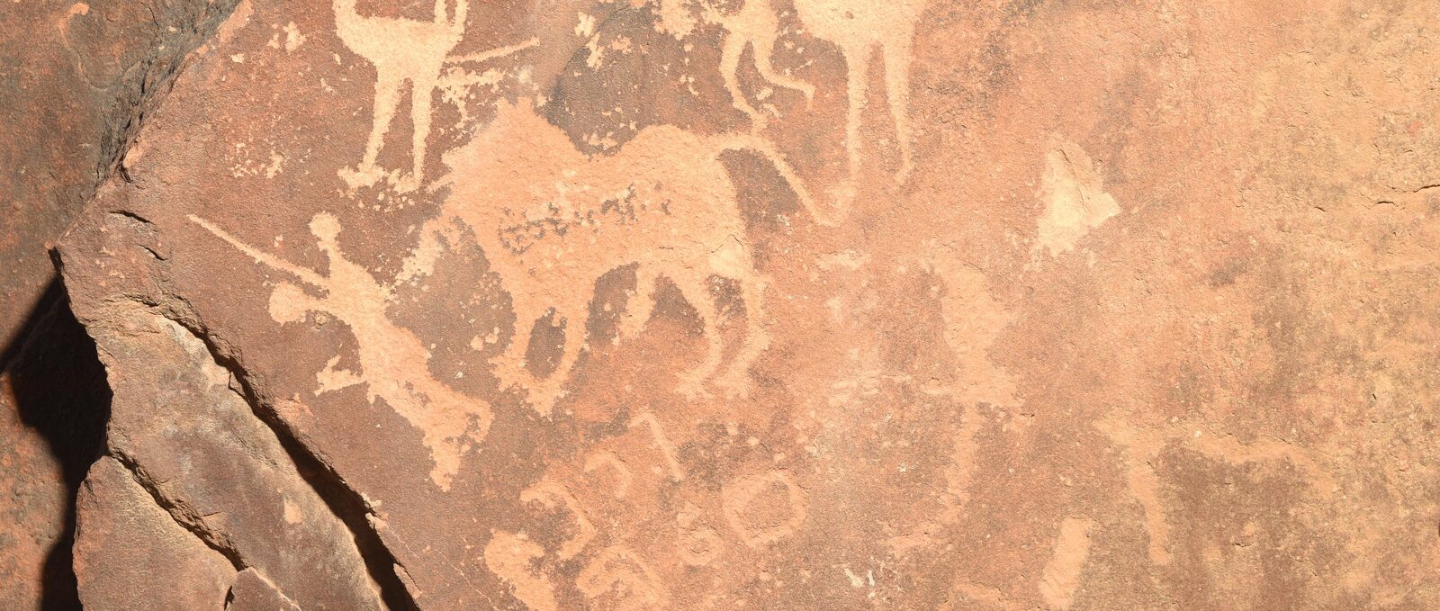 Ancient rock inscriptions and petroglyphs on a sandstone panel, Wadi Rum, Jordan
